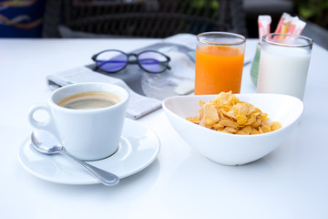 Breakfast set with cornflakes and cup of coffee and orange juice