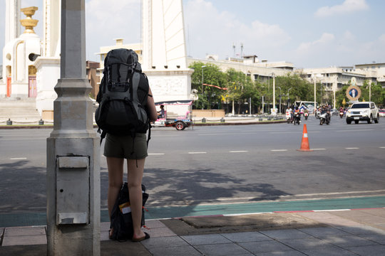 Traveler woman with backpack  standing waiting for taxi