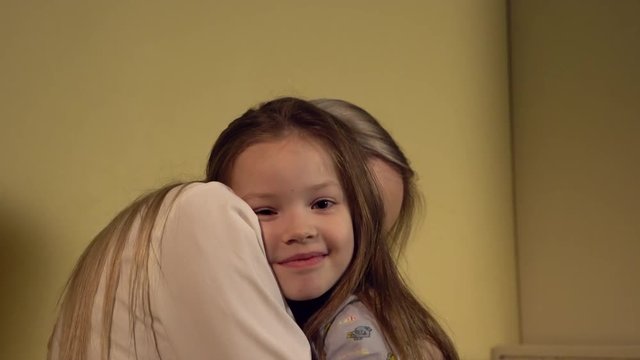 Mom and daughter cuddling before sleep.