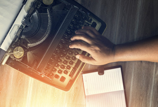 Womans hands typing on a vintage typewriter