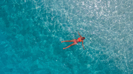 Aerial photo of girl in blue water of Indian ocean