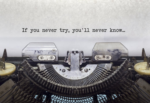 Vintage typewriter on white background with text If you never try, you'll never know.