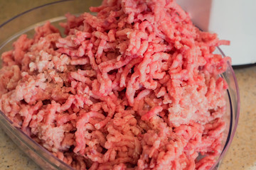 Close-up of minced meat coming out from grinder