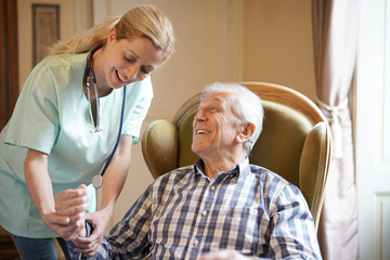 Nurse checking senior man blood pressure