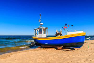 Naklejka na ściany i meble VIbrant fishing boats on the sandy beach of Baltic sea in Sopot, Poland