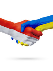 Flags Monaco, Ukraine countries, partnership friendship handshake concept.