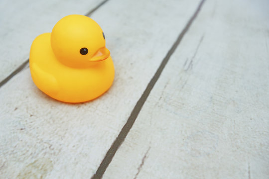 yellow duck toys over wooden table backgrounds