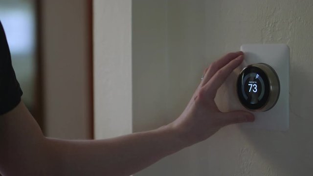 Man Adjusting Smart Thermostat Gadget At Home