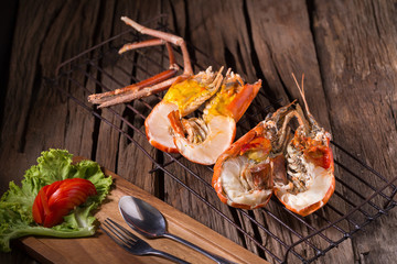 grilled giant river prawn with yellow creamy fat on head on a wooden plate