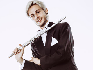 Male flutist wearing tailcoat holds flute