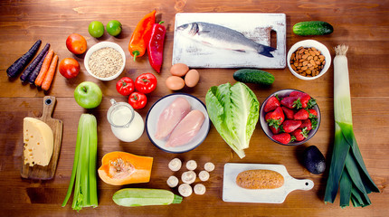 Vegetables, fruit, fish and meat on a wooden background. Balanced diet.