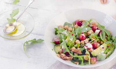 Healthy salad with chickpea, arugula, grape, walnut  and avocado.