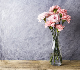 Pink carnation flowers in clear bottle with copy space