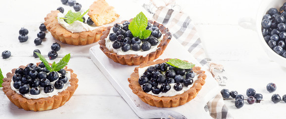 Blueberry tarts on white wooden table