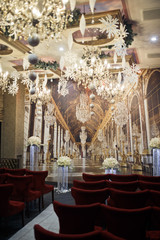 Obraz premium Red soft chairs stand in the rows before wall with picture of luxury corridor on it