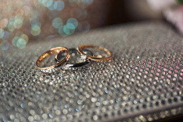 Obraz na płótnie Canvas Sparkling wedding rings on elegant handbag
