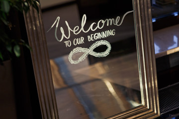 Lettering 'Welcome to our beginning written on the mirror