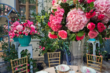 Mirror stands behind blue vases with flowers on the backyard