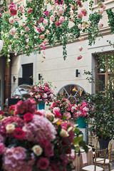 Look over large pink bouquets under garland of flowers