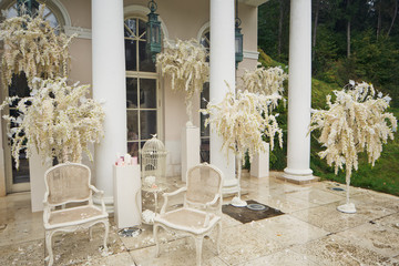 Branches with white flowers hang from the vases