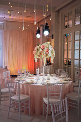 Yellow lights hang over pink dinner table covered with pink cloth