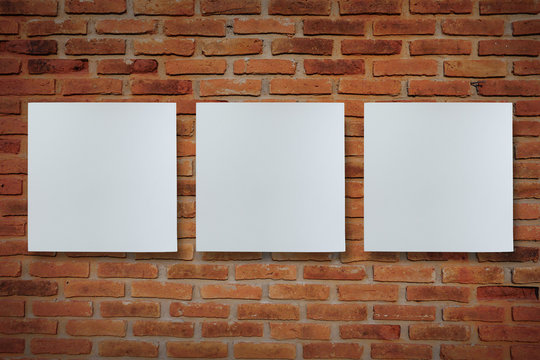 Three canvas frame on brick wall for image advertising. Red brick wall background.