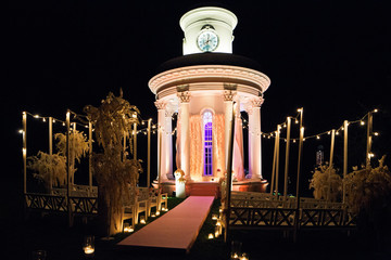 Obraz premium Yellow lights shine around white bower in the darkness