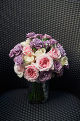 Violet wedding bouquet stands on grey chair
