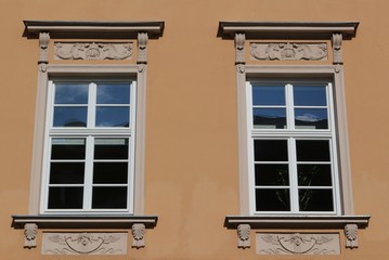 Vintage windows decorated with rich ornaments on orange wall In the Maximillian street, Augsburg,...