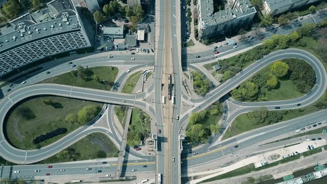 High altitude aerial shot of big urban road junction on a sunny day, top down view. 4K video
