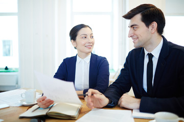 Businessman pointing at paper while discussing financial data with colleague