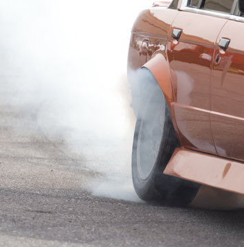 Smoke from under the wheels of the car