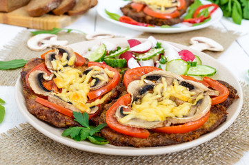 Chops baked with mushrooms, tomatoes and cheese on a white wooden background. Meat 