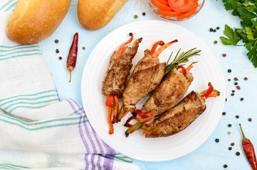 Meat rolls stuffed with sweet pepper, carrots on a light background. The top view