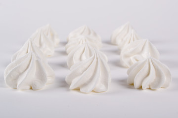 Closeup of mini meringues cookies on white background
