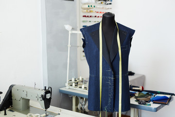 Tailoring studio interior: mannequin and working tables with sewing machines in empty workshop