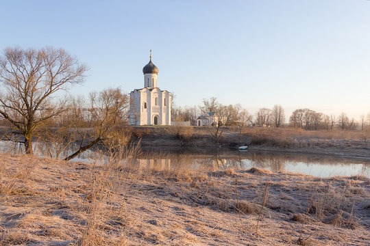 View to the Church of the Intercession of the Holy Virgin on the Nerl River in sunlight.