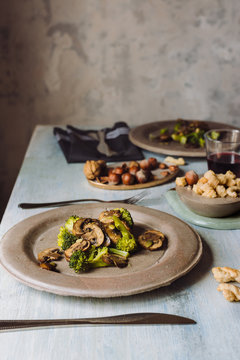 Close up of sauteed mushrooms with broccoli served on concrete plate