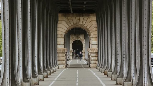 Metal Columns of Historical and famous Bir-Hakeim bridge in Paris.People walks and make jogging under the bridge.