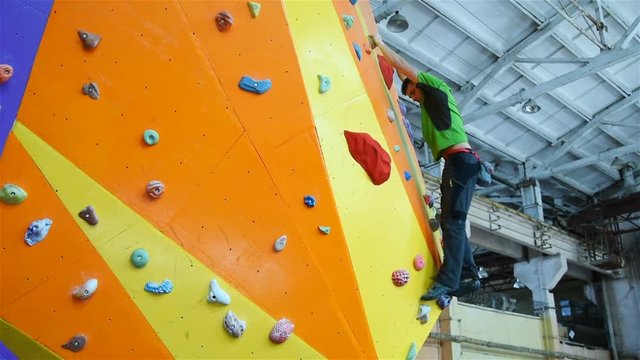 Climber Man On Artificial Climbing Wall In Bouldering Gym