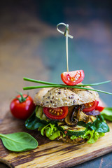 Vegetarian burger with grilled vegetables and fresh lettuce.
