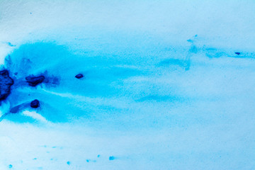 Blue paint watercolor dried on a piece of paper. Stains of blue paint on a white sheet. Abstraction of blue paint texture background.
