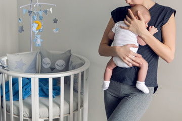 mother sleeping on the chest of his son is at round bassinet at home
