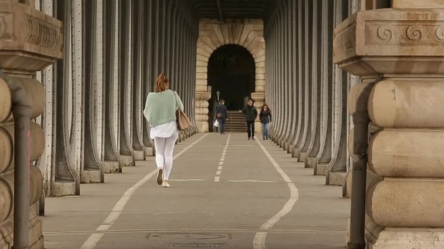 Metal Columns of Historical and famous Bir-Hakeim bridge in Paris.People walks and make jogging under the bridge.
