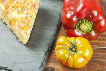 Potato omelette, a pepper and a tomato. Spanish
