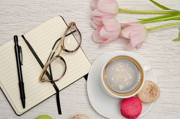 Planning of affairs. Coffee mug with dessert, notebook, pen and glasses.