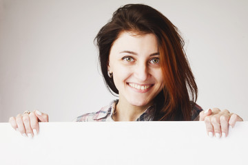 Woman peeking behind a whiteboard
