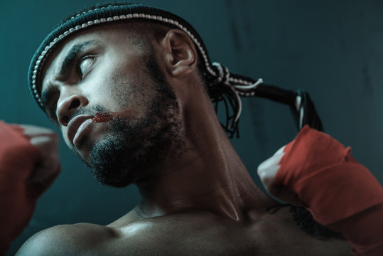 Close-up Portrait Of Determined Muay Thai Fighter With Blood On Face Looking Away, Ultimate Fight Concept