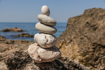 Fototapeta na wymiar Pebbles stacked up in a pyramid on the sea shore
