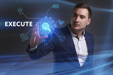 Business, Technology, Internet and network concept. Young businessman working on a virtual screen of the future and sees the inscription: Execute